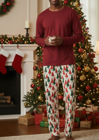 Unique tall Black man wearing Christmas Tree men’s pajama pants with a navy shirt beside a Christmas tree