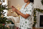 Green Snowflake short sleeve pajama top while decorating a tree