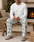 Man holding cocoa in Green Snowflake pants and a white shirt