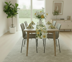 Dining room with a table set for a meal, decorated with a floral tablecloth and centerpieces.