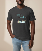A man wearing a dark charcoal gray t-shirt with a graphic that reads 'Rise & Garden' in light blue, above a string of colorful garden-themed clothespins spelling 'GARDEN'. He is wearing light blue jeans against a solid beige background.