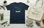 A navy blue t-shirt and a cream canvas tote bag, both printed with the phrase 'Rise & Garden' and a small clothesline graphic, arranged in a styled flat-lay on a white wooden surface with gardening props including gloves, a trowel, a mug, and greenery.