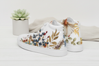White high-top sneakers with floral design on a light background