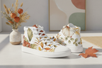 White sneakers with floral design on a light surface with decorative elements.